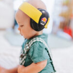 Baby wearing yellow on black earmuffs
